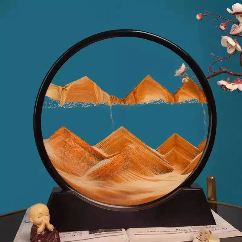 Round sand art frame with orange sand mountains on black stand, decorative monk statue and cherry blossoms