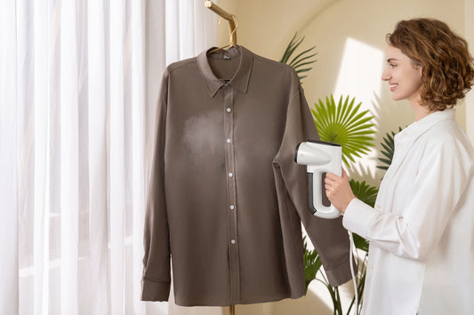 A woman using a hair dryer to dry a shirt