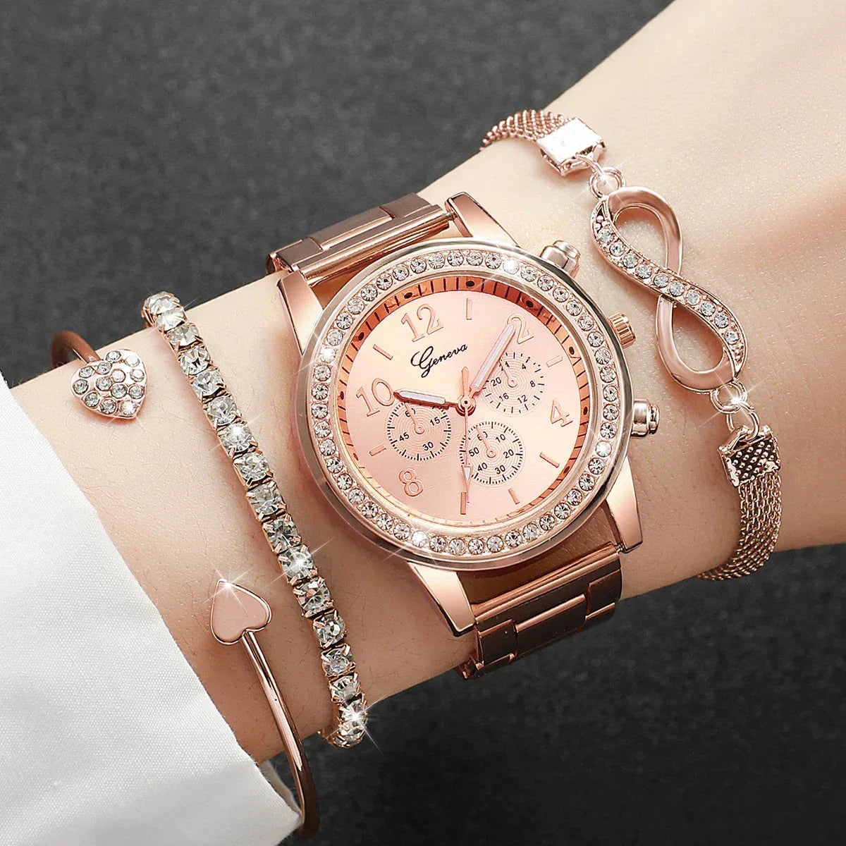 Rose gold Geneva wristwatch with rhinestone bezel and three matching bracelets on wrist