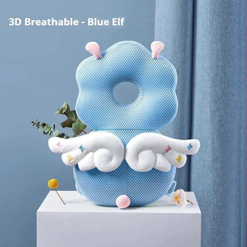 Blue elf-shaped 3D breathable baby pillow with white wings and pink antennae on white pedestal