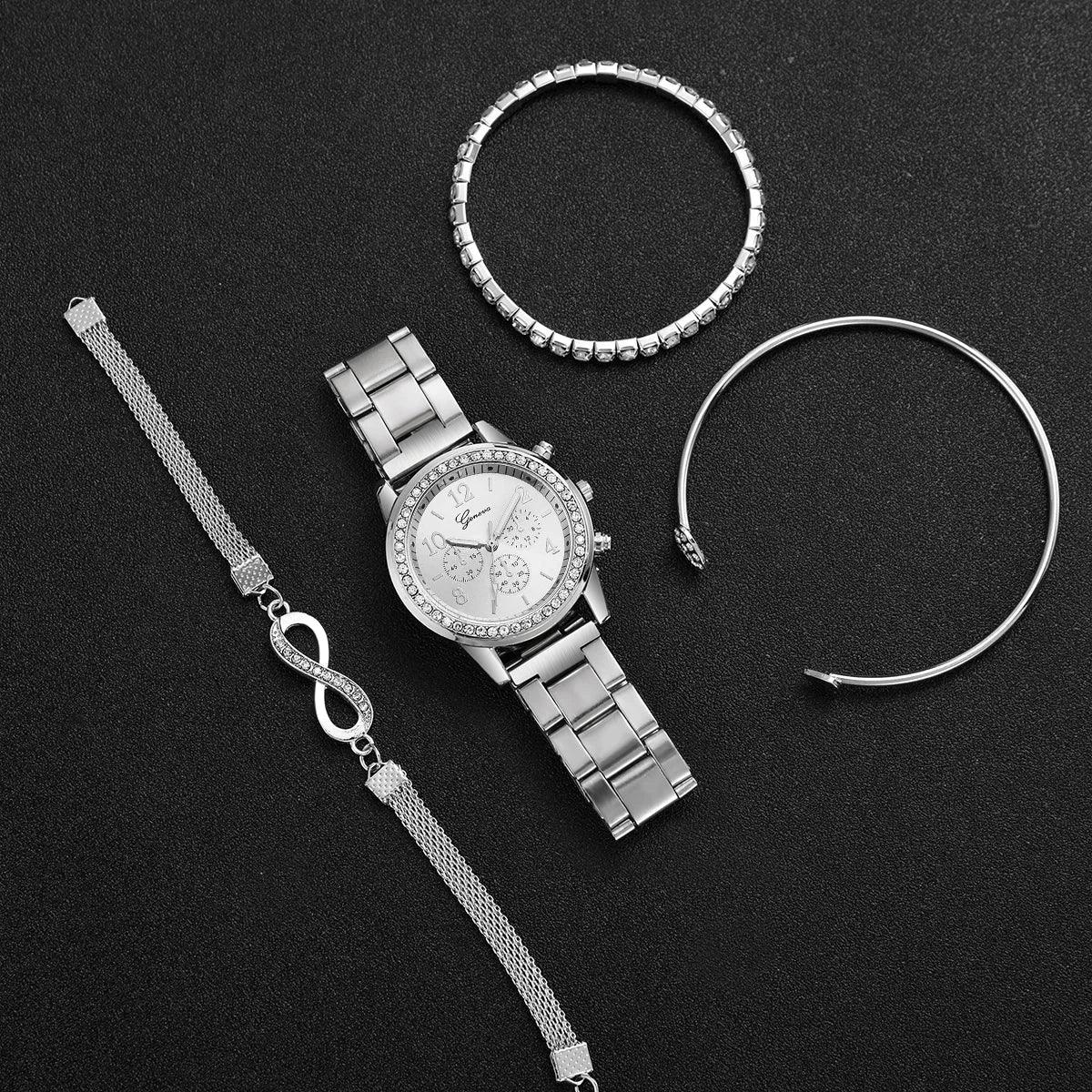Silver wristwatch with crystal bezel and three silver bracelets on black background