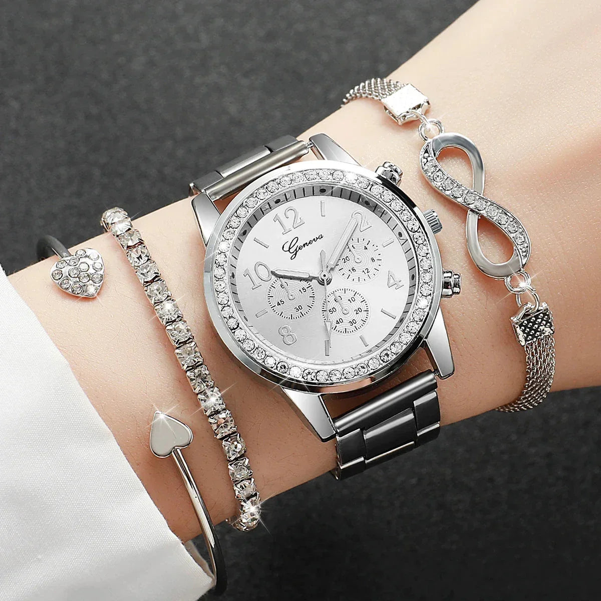 Silver Geneva watch with crystal bezel and three silver bracelets on wrist