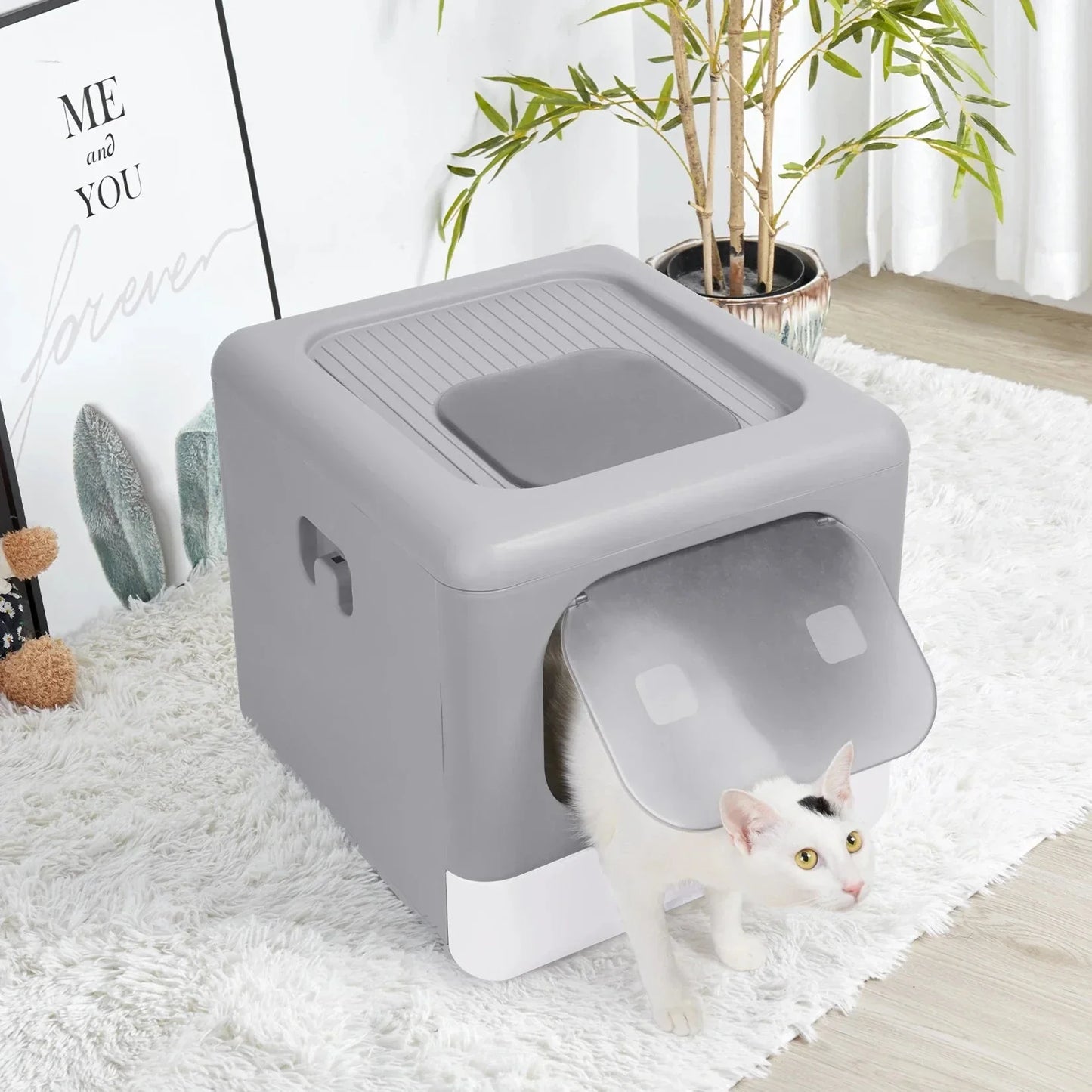 White cat entering gray plastic enclosed litter box with flap door on white rug