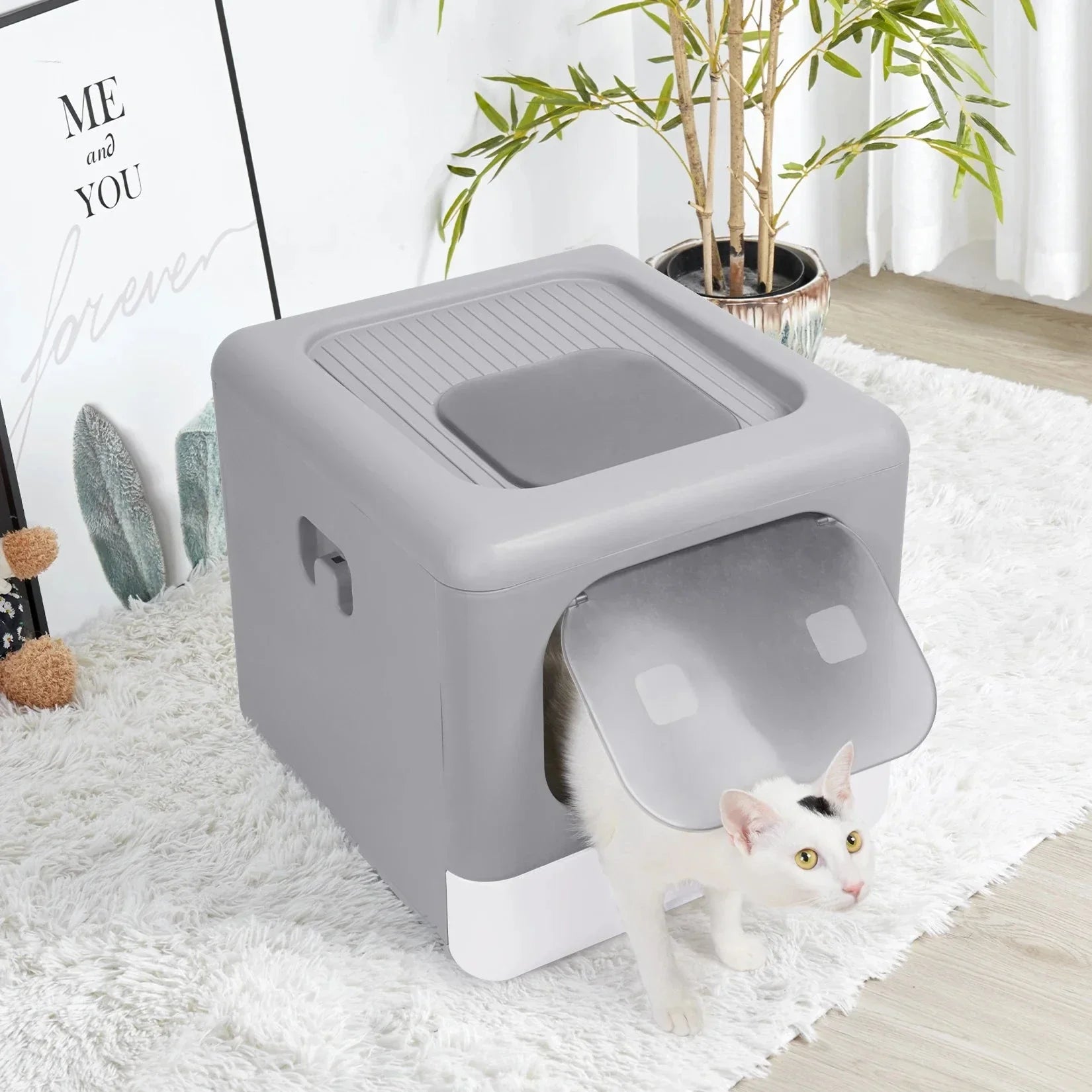 White cat entering gray plastic enclosed litter box with flap door on white rug