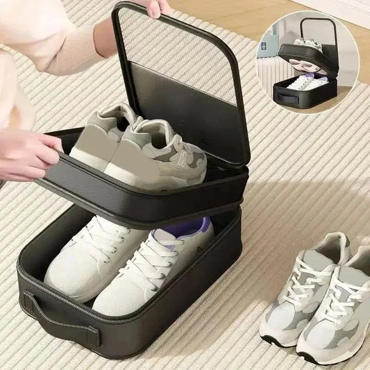 Black portable shoe storage box with handle holding white sneakers inside on light carpet