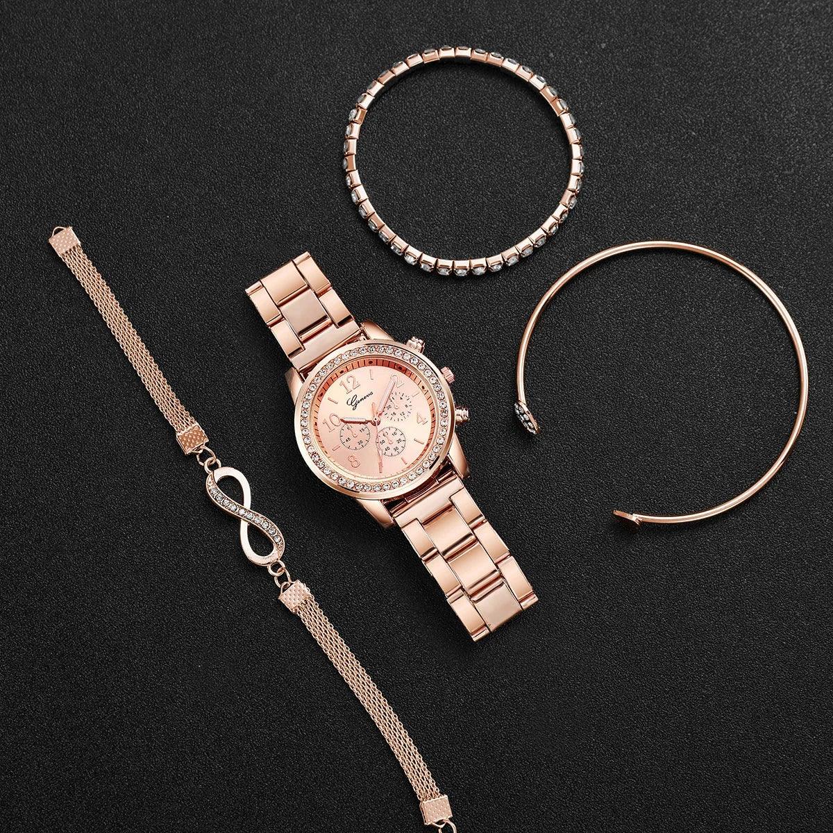 Rose gold wristwatch with crystal bezel next to three rose gold and crystal bracelets on black surface