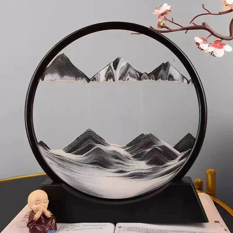 Decorative round sand art with black and white mountain landscape inside, displayed on black stand