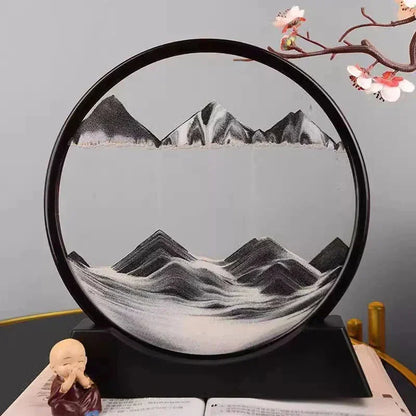 Decorative round sand art with black and white mountain landscape inside, displayed on black stand