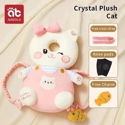 White cat-shaped plush baby head protector with pink bow and straps, includes knee pads and fish charm